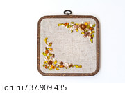 Needlework and hobbies. Hand embroidery with satin ribbons of a floral ornament at the corners of a square frame on a white background (embroidery was made by the author of the photo). Flat lay, copy space, close-up. Стоковое фото, фотограф Виктория Катьянова / Фотобанк Лори