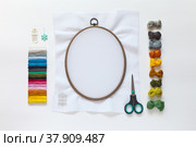 Accessories for embroidery: needles, set of colored mouline threads, needle threader, scissors and cotton canvas on the oval  hoop for stitch or cross-stitch embroidery. Copy space, flat lay, top view. Стоковое фото, фотограф Виктория Катьянова / Фотобанк Лори