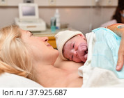 Mom and newborn baby skin to the skin after birth in the hospital. Стоковое фото, фотограф Irina Kuchugurina/Gaudy / Фотобанк Лори