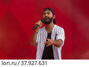 Рэпер Мот (Матвей Мельников) во время выступления на концерте в рамках торжественной церемонии финиша международного ралли "Шелковый путь" в "Лужниках" города Москвы, Россия (2022 год). Редакционное фото, фотограф Николай Винокуров / Фотобанк Лори