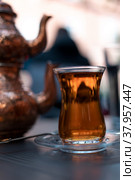 Turkish traditional tea in tulip-shaped glass with cupper colored double teapot. Стоковое фото, фотограф Юлия Паутова / Фотобанк Лори
