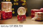 Christmas snowglobe and Christmas gifts on table. Стоковое видео, видеограф Сергей Толмачёв / Фотобанк Лори