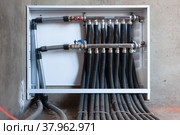 Modern plumbing manifold system tubing for house water distribution, control valves home water pipe, close-up human hand opening valve. Стоковое фото, фотограф Марина Шабардина / Фотобанк Лори