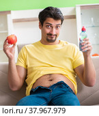 Man suffering from extra kilos in dieting concept. Стоковое фото, фотограф Elnur / Фотобанк Лори