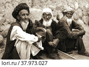Афганские старики сидят на корточках у стены дома (2005 год). Редакционное фото, фотограф Виталий Михайлюк / Фотобанк Лори