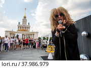 Артистка в образе Аллы Пугачевой выступает перед зрителями на Главной аллее ВДНХ во время празднования дня рождения выставки в городе Москве, Россия (2022 год). Редакционное фото, фотограф Николай Винокуров / Фотобанк Лори