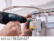 Mounting fuse box for distribution board. Fastening circuit breakers to DIN rail of consumer unit of electrical panel. Стоковое фото, фотограф Владимир Григорьев / Фотобанк Лори