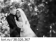 Портрет межрасовых молодоженов, которые обнимаются на фоне красивого лесного пейзажа, черно белая  фотография. Стоковое фото, фотограф Иванов Алексей / Фотобанк Лори