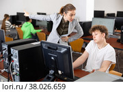 Strict teacher reprimanding negligent teenage student in computer class. Стоковое фото, фотограф Яков Филимонов / Фотобанк Лори