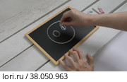 A woman draws a face with a smile on a table with chalk on a children's blackboard. Стоковое видео, видеограф Катерина Белякина / Фотобанк Лори