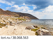 Baikal Lake. Sandy beach and rocky shore in the shallow bay of Ust-Anga. Tourists travel along the coast and explore the surroundings. Стоковое фото, фотограф Виктория Катьянова / Фотобанк Лори