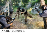 Group of friends paintball players of opposite teams in shootout in forest. Стоковое фото, фотограф Яков Филимонов / Фотобанк Лори