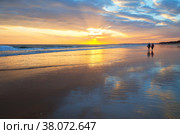 Magnificent southern sunset on the sea. Silhouettes of people walking along the shore of the Atlantic Ocean on a warm evening. Natural summer background. Beautiful seascape. Vilamoura, Falesia, Algarve, Portugal (2012 год). Стоковое фото, фотограф Виктория Катьянова / Фотобанк Лори