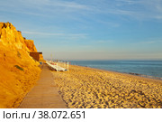 Comfortable Falesia beach with wooden walkways and sun beds at the terracotta rocks on the shallow sandy seashore. Vilamoura, Algarve, Portugal. Natural background Summer holiday by the sea (2012 год). Стоковое фото, фотограф Виктория Катьянова / Фотобанк Лори
