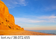 Portugal. Algarve. Vilamoura. The famous Falesia Beach with a shallow sandy beach of the Atlantic Ocean, bordered by unusual red rocks at sunset. Summer vacation by the sea. Natural background (2012 год). Стоковое фото, фотограф Виктория Катьянова / Фотобанк Лори