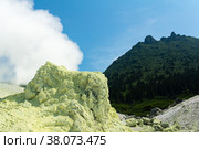 Bright smoking fumarole with sulfur deposits against the background of the Mendeleev volcano peak on the island of Kunashir. Стоковое фото, фотограф Евгений Харитонов / Фотобанк Лори