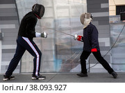 Спортсмен демонстрирует мастер класс фехтования шпаге ребенку на Тверской улице в День города Москвы, Россия (2022 год). Редакционное фото, фотограф Николай Винокуров / Фотобанк Лори