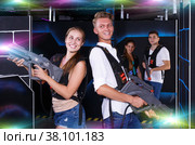 Excited team of laser tag winners guy and girl with laser pisto. Стоковое фото, фотограф Яков Филимонов / Фотобанк Лори