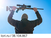 Capitulating soldier sniper rifles with an optical sight in man`s hands give up winter day blue sky (2022 год). Редакционное фото, фотограф Camptoloma / Фотобанк Лори