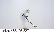 Man in white chemical protection suit holds metal detector. Стоковое видео, видеограф Aleksey Kidisyuk / Фотобанк Лори