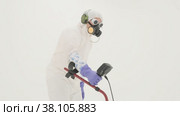 Man in white chemical protection suit holds metal detector. Стоковое видео, видеограф Aleksey Kidisyuk / Фотобанк Лори