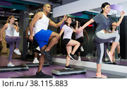 Group of people working out with steppers in fitness center. Стоковое фото, фотограф Яков Филимонов / Фотобанк Лори