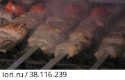 Close-up of lumpy kebab with tomato and ground kebab is grilled on the grill. Стоковое видео, видеограф Aleksey Kidisyuk / Фотобанк Лори