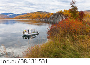 BAIKAL LAKE, SLUDYANKA VILLAGE, IRKUTSK REGION, RUSSIA - September 18, 2022: A family with children travels on a pleasure boat around the famous Cape Shamansky on an autumn day. Редакционное фото, фотограф Виктория Катьянова / Фотобанк Лори