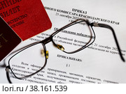 Приказ комиссара Краснодарского края "Об объявлении мобилизация" и военный билет лежат на столе (2022 год). Редакционное фото, фотограф Николай Винокуров / Фотобанк Лори