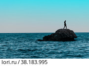 A man on a lonely stone island in the middle of the sea. Стоковое фото, фотограф Ярославский Максим / Фотобанк Лори