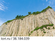 Top of columnar volcanic basalt cliff against the background of the sky with clouds. Стоковое фото, фотограф Евгений Харитонов / Фотобанк Лори
