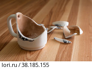 Разбитая белая чашка с осколками на деревянном фоне. Broken white Cup with shards on a wood background. Стоковое фото, фотограф Марина Шабардина / Фотобанк Лори