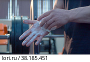 Bodybuilder chalking his hands. Beginning of workout. Стоковое фото, фотограф Chudakov_Ivan / Фотобанк Лори