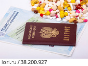 Бесплатная медицина. Российский паспорт, СНИЛС и полис на фоне разноцветных таблеток. Стоковое фото, фотограф Владимир Ходатаев / Фотобанк Лори