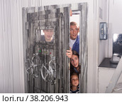 Close-knit family tries to open the door to the quest room, stylized as a secret shelter. Стоковое фото, фотограф Яков Филимонов / Фотобанк Лори