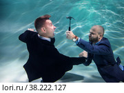 Successful businessman elimination of competitor young business start-up with resistance underwater. Live competition and monopolies in work. Concept bad partnership and goal achievement. Copy space. Стоковое фото, фотограф Aleksandr Golubev / Фотобанк Лори