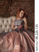 Pretty, slender woman with violin. Female in stage image retro costume. Emotions of girl in dress sitting in interior textured room. Actress shows her abilities. Author space in photo. Стоковое фото, фотограф Aleksandr Golubev / Фотобанк Лори