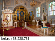 Orthodox church. Candles, cross, icon, prayer book, candles and Bible on table, Iconostasis, baptismal font. Preparing for baptism of newborn child in Holy water. Sacrament of baptism. Стоковое фото, фотограф Aleksandr Golubev / Фотобанк Лори