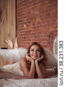 Pretty slender woman with wings. Female in stage image of an angel. Emotion girl in dress lying on bed in an old textured room. Actress shows her abilities. Concept of theatrical premiere. Copy space. Стоковое фото, фотограф Aleksandr Golubev / Фотобанк Лори