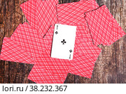 Playing cards scattered on table. Background of scattered deck cards filling inverted reverse side with cross ACE to top entire on textured wooden. Top view, close-up. Copyright space for site. Стоковое фото, фотограф Aleksandr Golubev / Фотобанк Лори