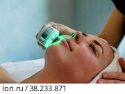Beautician doing led light therapy to woman in SPA salon, facial phototherapy for skin pore cleaning. Стоковое фото, фотограф Aleksandr Golubev / Фотобанк Лори