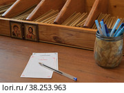 Бланки записок о здравии и о упокоении и шариковая ручка лежат на столе в церковной свечной лавке. Стоковое фото, фотограф Владимир Литвинов / Фотобанк Лори