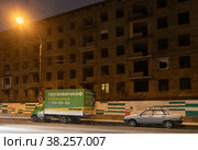 Москва, микрорайон Марфино, улица Академика Комарова, 8. Дом включен в первую очередь программы реновации, расселен, огорожен и подготовлен под снос. Ночь, идет густой снег. В пустом доме светится единственное  окно (2022 год). Редакционное фото, фотограф Наталья Николаева / Фотобанк Лори