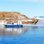 Frozen Baikal Lake. The Hivus hovercraft transports tourists across the Olkhon Gate Strait from Olkhon Island to the village of Sakhyurta. Cows graze on a coastal hill on a sunny cold day. Winter travel. Стоковое фото, фотограф Виктория Катьянова / Фотобанк Лори