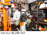 Considerate customer chooses washer at garden tool store. Стоковое фото, фотограф Яков Филимонов / Фотобанк Лори