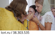 RUSSIA, KAZAN 08-28-2022: priest drips oil on a baptized crying baby. Редакционное видео, видеограф Константин Шишкин / Фотобанк Лори