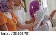 RUSSIA, KAZAN 08-28-2022: two women recite a prayer from a page in a Christian church. Редакционное видео, видеограф Константин Шишкин / Фотобанк Лори