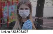 Girl in medical mask and rubber gloves on street. Стоковое видео, видеограф Aleksandr Golubev / Фотобанк Лори