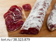Slicing delicious Spanish smoked sausage fuete. Стоковое фото, фотограф Яков Филимонов / Фотобанк Лори