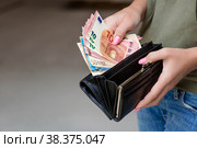 Women's hands close-up. A woman holds Euro banknotes and a wallet for money. The concept of business, Finance, and remuneration. Стоковое фото, фотограф Photojuli / Фотобанк Лори